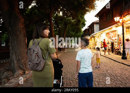 Mère et fils marchant dans les rues de la vieille ville de Nessebar en soirée d'été. Banque D'Images