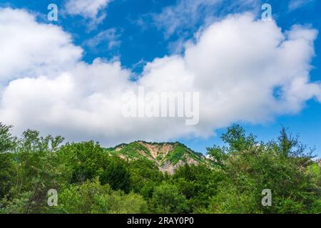 Beaux nuages épais au-dessus de la roche dans le ciel bleu Banque D'Images