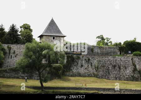 Cette image montre un parc serein niché le long de la pittoresque rivière Vrbas, avec la majestueuse forteresse de Kastel dominant au-dessus. Un mélange harmonieux de natur Banque D'Images