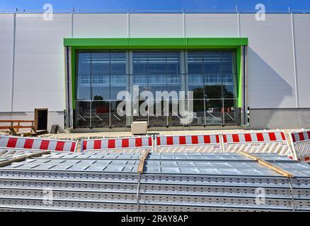 06 juillet 2023, Brandenburg, Cottbus : façade du nouveau hall sur le chantier de construction de l'usine de maintenance des trains ICE. Deutsche Bahn a commencé la construction de la nouvelle usine ferroviaire de Cottbus en mai 2022. Le premier de ce qui sera plus tard deux ateliers est construit ici. À partir de janvier 2024, les premiers trains ICE 4 d’environ 400 mètres de long seront techniquement entretenus et réparés dans cette salle. Plus de 300 nouveaux employés et stagiaires se sont déjà inscrits pour la future usine DE GLACE. Deutsche Bahn prévoit de créer un total de 1 200 apprentissages et emplois dans la nouvelle usine de Cottbus d'ici 2 Banque D'Images