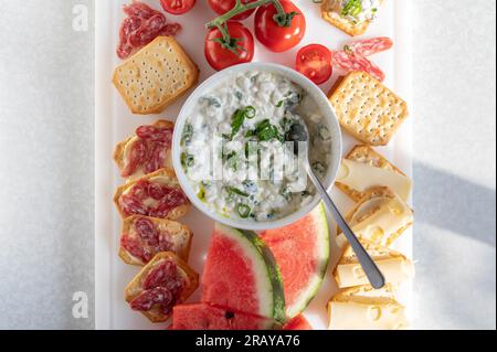 Apéritif avec pastèque, fromage et craquelins sur un plateau blanc Banque D'Images