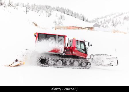 Véhicule rouge snowcat préparant les pistes de ski. Banque D'Images