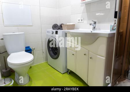 Intérieur de salle de bains avec lavabo blanc, wc et machine à laver Banque D'Images