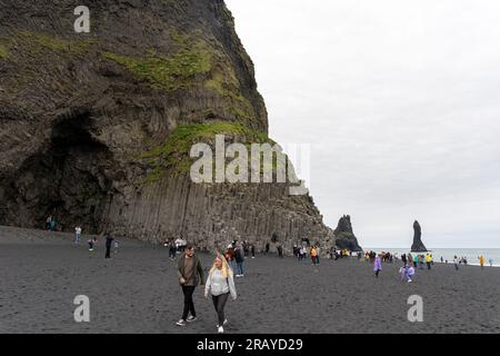 Plage de sable noir de Reynisfjara, Islande - 06.22.2023 : touristes aux colonnes de basalte sur la plage de Reynisfjara Banque D'Images