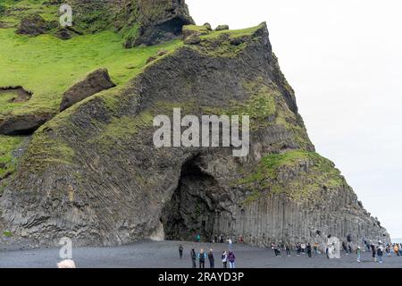 Plage de sable noir de Reynisfjara, Islande - 06.22.2023 : touristes aux colonnes de basalte sur la plage de Reynisfjara Banque D'Images