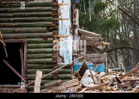 Fragment du mur brisé d'une vieille maison en bois. Démolition d'un bâtiment de deux étages Banque D'Images