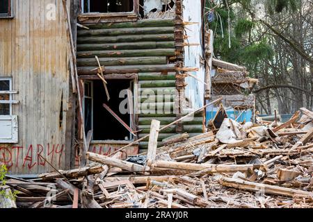 Fragment du mur brisé d'une vieille maison en bois. Démolition d'un bâtiment de deux étages Banque D'Images