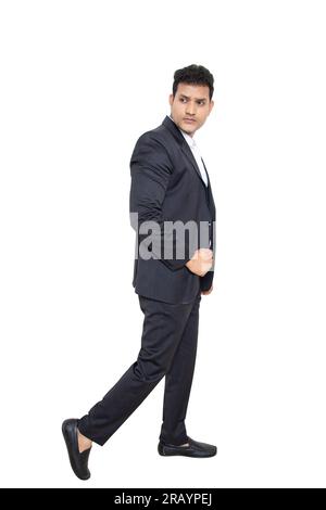 Beau jeune homme d'affaires indien portant costume debout posant isolé sur fond blanc. Concept d'entreprise. Banque D'Images