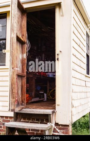 Newbury, Massachusetts - Une vue de l'intérieur d'un hangar à outils à l'intérieur d'une grande grange laitière en bois beige et de l'herbe verte à l'historique Spencer Pierce éclairé Banque D'Images