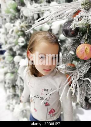 Petite fille avec des cadeaux de Noël près d'un arbre de Noël à la maison. Photo de haute qualité Banque D'Images