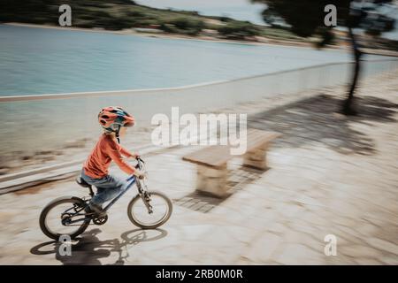 Garçon faisant du vélo sur la promenade Banque D'Images