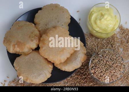 Puris de blé Khapli. Pain plat indien frit à base de farine de blé Emmer servi avec de la main de crevette, yaourt sucré populaire en Inde. Une version de puri Banque D'Images