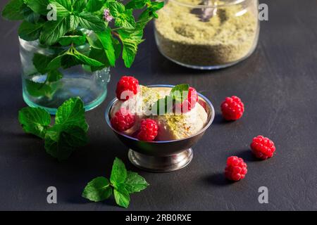 Crème glacée aux framboises et à la menthe dans un bol en fer sur une surface en béton. Banque D'Images