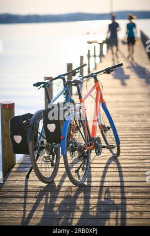 Couple, homme et femme voyageant avec des vélos, vélo de trekking, reposant sur la jetée Banque D'Images