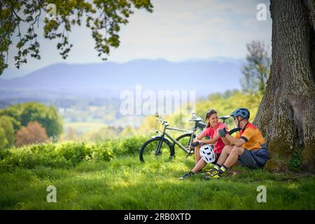 Couple, homme et femme voyageant avec des vélos, repos, pause, vélo de trekking, e-bike Banque D'Images