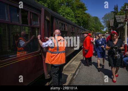 Reconstitution nostalgique des années 1940 (mode rétro, vieux matériel roulant, chariot stationnaire, porte ouverte) - KWVR, Haworth Station, West Yorkshire, Angleterre, Royaume-Uni. Banque D'Images