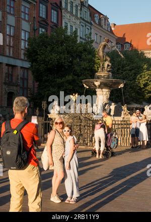 Touristes à la fontaine de Neptune et statue à Dlugi Targ, vieille ville de Gdansk, Pologne Banque D'Images