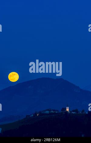 Waidhofen an der Ybbs, montée de pleine lune, hameau et église Windhag, poiriers en fleurs, prairies, fermes à Mostviertel, Basse-Autriche, Autriche Banque D'Images