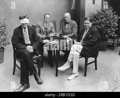 New York, New York : c. 1929 l'expert en Bridge William McKenney démontre son habileté à jouer contre trois tables de 'Blindfold Bridge'. Les joueurs appellent les cartes comme ils sont joués et donc il doit mémoriser trois jeux de cartes comme ils sont joués. À cette table du Park Central Hotel se trouvent les joueurs experts Walter Weyman, Milton Work et R.R. Richards Banque D'Images