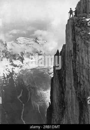 Suisse : c. 1924 deux randonneurs dans les Alpes suisses au bord d'un précipice. Banque D'Images