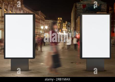 Deux panneaux d'affichage de rue vierges la nuit. Isolé avec le chemin de détourage autour de l'affichage publicitaire. Banque D'Images