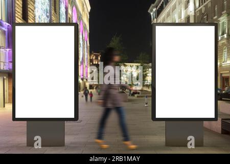 Deux panneaux d'affichage de rue vierges la nuit. Isolé avec le chemin de détourage autour de l'affichage publicitaire. Banque D'Images