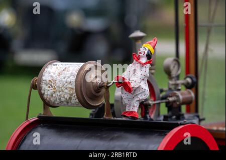 Pakruojis, Lituanie. 1 juillet 2023 : vieille décoration de machine à pop-corn - un clown tourne un baril transparent avec du pop-corn Banque D'Images