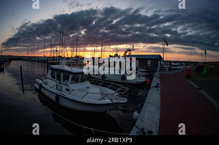 Glowe, Allemagne. 06 juillet 2023. Le soleil couchant colore le ciel au-dessus du port de Glowe sur la côte de l'île de Rügen. Rügen est l'aimant touristique parmi les îles allemandes. Plus de 1,2 millions d'invités ont visité la plus grande île allemande l'année dernière, comme l'ont annoncé mardi les offices statistiques de Basse-Saxe, Mecklembourg-Poméranie occidentale, Hambourg et Schleswig-Holstein. Crédit : Stefan Sauer/dpa/Alamy Live News Banque D'Images