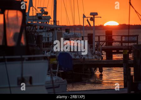 Glowe, Allemagne. 06 juillet 2023. Le soleil couchant colore le ciel au-dessus du port de Glowe sur la côte de l'île de Rügen. Rügen est l'aimant touristique parmi les îles allemandes. Plus de 1,2 millions d'invités ont visité la plus grande île allemande l'année dernière, comme l'ont annoncé mardi les offices statistiques de Basse-Saxe, Mecklembourg-Poméranie occidentale, Hambourg et Schleswig-Holstein. Crédit : Stefan Sauer/dpa/Alamy Live News Banque D'Images