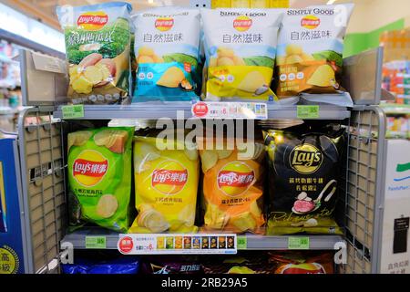 Croustilles Lay's aux saveurs locales variées sur un présentoir dans un Family Mart à Taipei, Taiwan ; marque américaine adaptée aux goûts et aux palais locaux. Banque D'Images