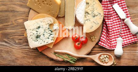 Planche avec différentes sortes de fromage sur fond en bois Banque D'Images