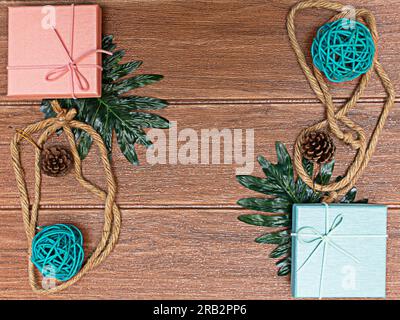 Boîtes-cadeaux de Noël à vue à angle élevé présentées sur plancher en bois rustique. Les cadeaux sont dispersés le long des bords du cadre, laissant un peu d'espace dedans Banque D'Images