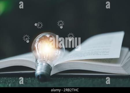 Ampoule lumineuse brillante et icône avec livre. Idée de réussite d'entreprise et concept d'éducation ou d'apprentissage en ligne. Réussite et inspiration des hommes d'affaires. tec Banque D'Images