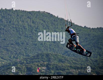 Kite surfeur en action tout en sautant avec la côte en arrière-plan Banque D'Images