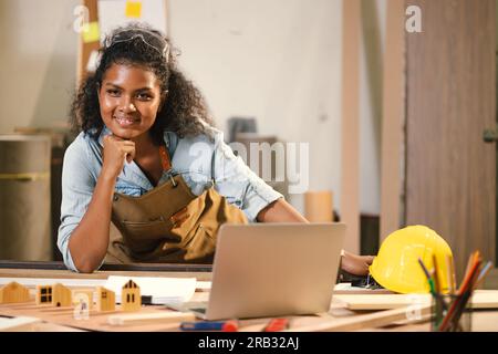 Menuisier Femme travaillant le bois dans l'atelier Designer Building Wood Home. Architecte femmes Smart Work. Happy Joiner Ingénieur en construction avec Design Floor Banque D'Images