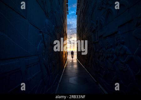 Silhouette d'un homme avec un vélo au bout du tunnel de la tour Nghinh Phong dans la province de Phu yen, Vietnam, surplombant la mer à l'aube Banque D'Images