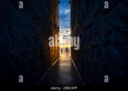 Silhouette d'un homme avec un vélo au bout du tunnel de la tour Nghinh Phong dans la province de Phu yen, Vietnam, surplombant la mer à l'aube Banque D'Images