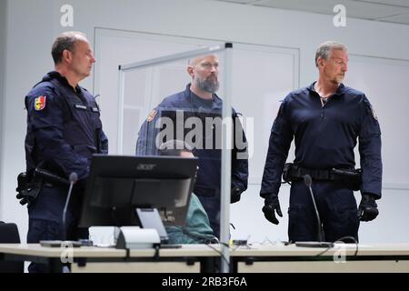 Itzehoe, Allemagne. 07 juillet 2023. Des officiers de justice se tiennent derrière le défendeur Ibrahim A. amené à son siège dans la salle d'audience du Centre logistique de Chine. Le procès d'Ibrahim A. pour l'attaque mortelle au couteau contre un train régional à Brokstedt, Schleswig-Holstein, Allemagne, le 25 janvier 2023, Commencé vendredi au tribunal régional d'Itzehoe. Crédit : Christian Charisius/dpa-POOL/dpa/Alamy Live News Banque D'Images