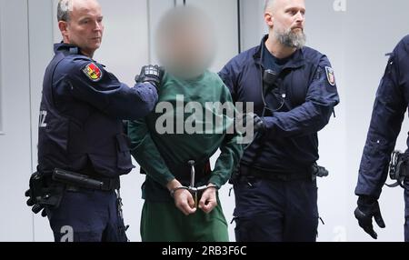 Itzehoe, Allemagne. 07 juillet 2023. Le défendeur Ibrahim A. est emmené à sa place dans la salle d'audience du Centre logistique de Chine par des fonctionnaires de la cour. Le procès d'Ibrahim A. pour l'attaque mortelle au couteau contre un train régional à Brokstedt, Schleswig-Holstein, le 25 janvier 2023, a débuté vendredi au tribunal régional d'Itzehoe. Credit : Christian Charisius/dpa-POOL/dpa - ATTENTION : personne(s) a(ont) été pixelisé(s) pour des raisons juridiques/dpa/Alamy Live News Banque D'Images