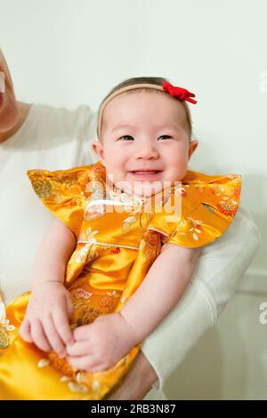 Bébé fille portant robe traditionnelle chinoise pour occasion spéciale Banque D'Images