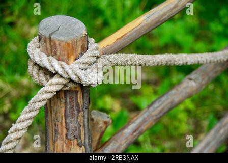 Corde attachée avec un crochet de girofle autour d'un poteau de clôture. Banque D'Images