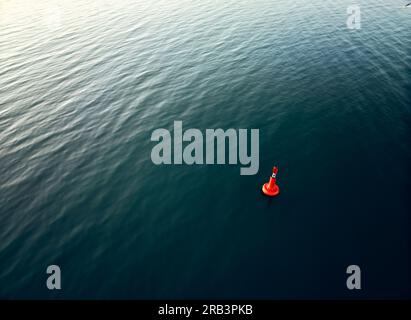 Bouée orange flottant dans la mer ondulante Banque D'Images