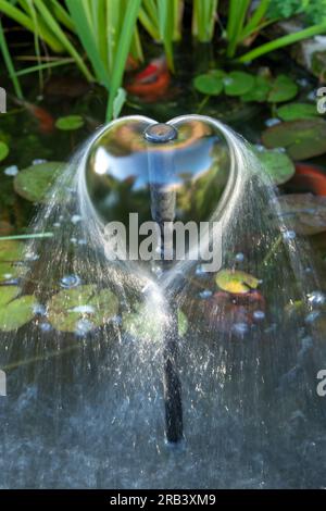 Fontaine d'eau d'étang de poisson en forme de coeur. ROYAUME-UNI Banque D'Images