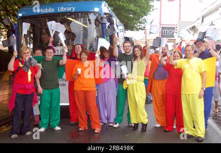 Manchester UK LGBT Pride Parade 2010 à travers le centre-ville Manchester, Royaume-Uni. Les membres et alliés du Manchester City Council LGBT Employee Group avec une bibliothèque mobile du conseil posent pour la photo avant le début du défilé. L'entrée du Conseil au défilé, avec un thème de bibliothèque et de livres de lecture, a été organisée par le Manchester City Council LGBT Employee Group avec le soutien des responsables du Conseil. Des vêtements multicolores lumineux illustrent le concept arc-en-ciel. Banque D'Images