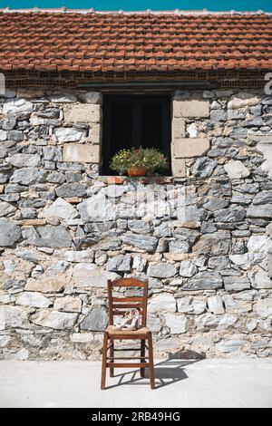 Traditioneller Holzstuhl vor einer Steinwand dans Griechenland Banque D'Images