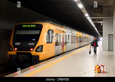 Train en gare avec passager sur le quai de la gare avec scooter électrique, Portugal Banque D'Images