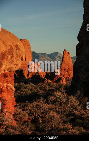 Vue sur la chaîne de montagnes la Sal à travers les formations rocheuses rouges du parc national des Arches dans l'Utah Banque D'Images