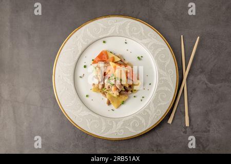 Poulet aigre-chaud sauté avec carottes, pommes de terre et courgettes. Cuisine asiatique Banque D'Images