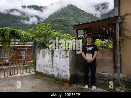 (230707) -- GONGSHAN, 7 juillet 2023 (Xinhua) -- Gan Wenyong est photographié à la bibliothèque 'Banshan Huayu' dans le village de Qiunatong, dans le canton de Bingzhongluo dans le comté autonome de Gongshan Dulong et nu, préfecture autonome de Lisu de Nujiang, province du Yunnan, au sud-ouest de la Chine, le 6 juillet 2023. La rivière Nujiang, descendant des montagnes Tanggula sur le plateau Qinghai-Tibet, se fraie un chemin à travers les majestueuses montagnes du Yunnan où se forme un magnifique canyon. Niché à l'extrémité nord du canyon de la rivière Nujiang se trouve le village de Qiunatong, qui abrite une bibliothèque unique appelée 'Banshan Hu Banque D'Images