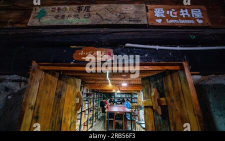 (230707) -- GONGSHAN, 7 juillet 2023 (Xinhua) -- Gan Wenyong participe à une activité de lecture avec des enfants à la bibliothèque 'Banshan Huayu' dans le village de Qiunatong, dans le canton de Bingzhongluo, dans le comté autonome de Gongshan Dulong et nu, préfecture autonome de Lisu de Nujiang, province du Yunnan, au sud-ouest de la Chine, le sud-ouest, le 5 juillet 2023. La rivière Nujiang, descendant des montagnes Tanggula sur le plateau Qinghai-Tibet, se fraie un chemin à travers les majestueuses montagnes du Yunnan où se forme un magnifique canyon. Niché à la pointe nord du canyon de la rivière Nujiang est le village de Qiunatong, qui abrite Banque D'Images